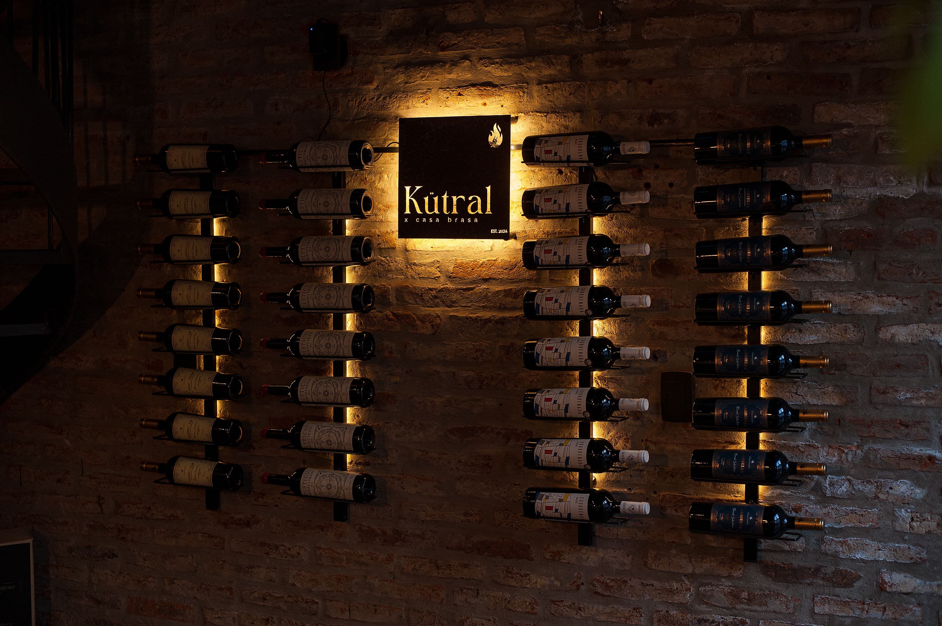 Pared de vinos y bodega de Kütral Casa Brasa